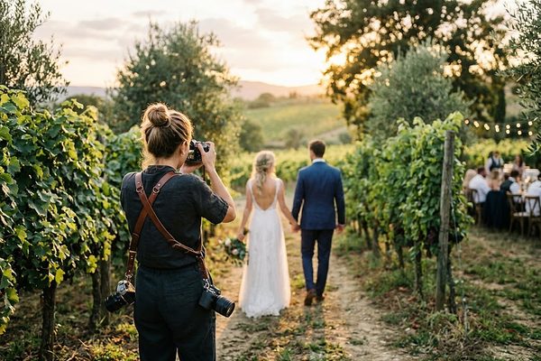 Isabel fotografiando a una pareja entre viñedos durante una boda